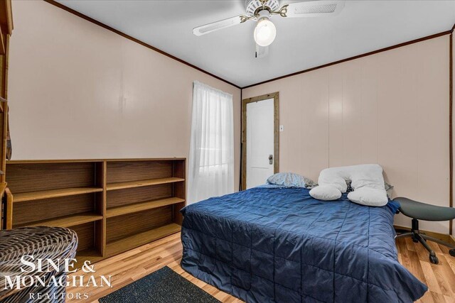 bedroom with light hardwood / wood-style flooring, ceiling fan, and ornamental molding