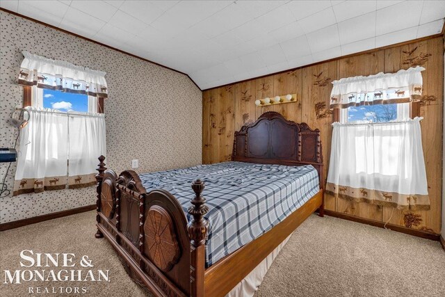 bedroom featuring lofted ceiling, carpet floors, crown molding, and wood walls