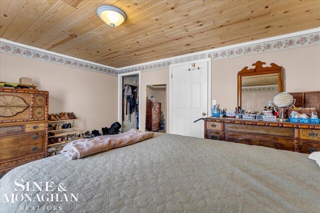 bedroom with wood ceiling, ornamental molding, and a closet