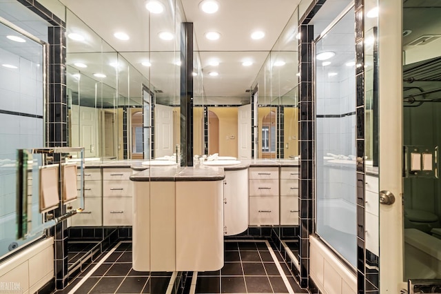 bathroom featuring tile patterned floors, vanity, and bath / shower combo with glass door