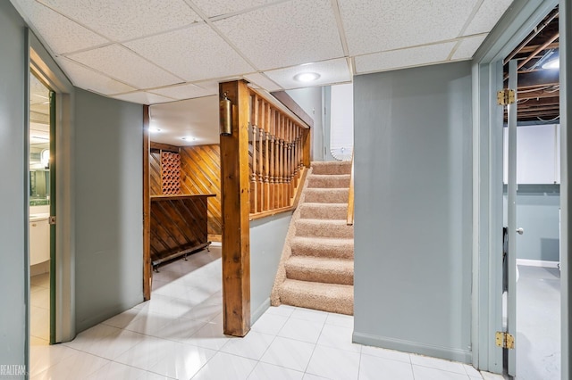 interior space featuring light tile patterned floors and a drop ceiling