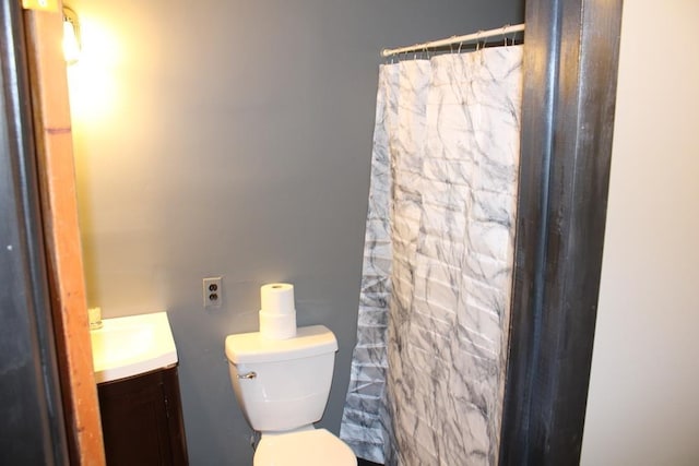 bathroom with a shower with curtain, vanity, and toilet