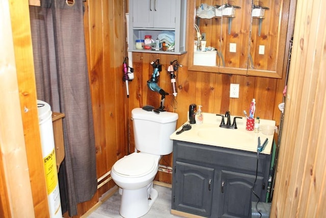 bathroom with vanity, toilet, wooden walls, and water heater