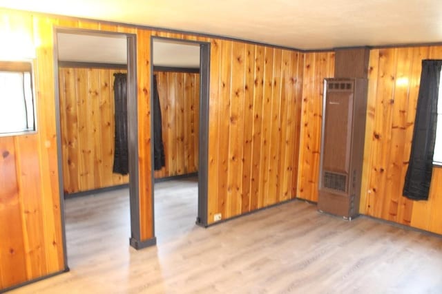 unfurnished bedroom featuring wooden walls and light hardwood / wood-style flooring