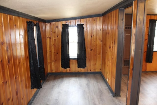 spare room with wood walls, dark hardwood / wood-style floors, and ornamental molding