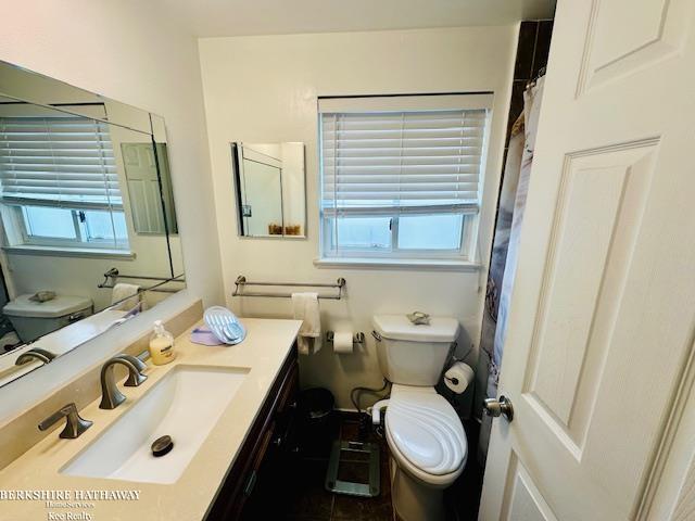 bathroom with a shower with curtain, vanity, and toilet