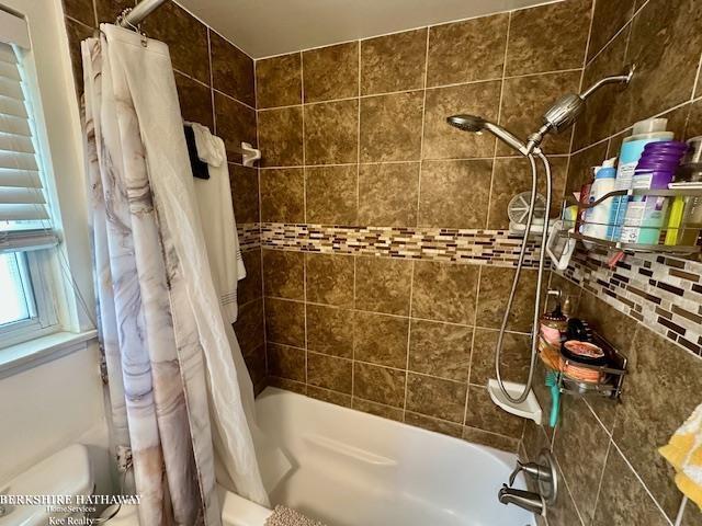 bathroom featuring backsplash and shower / tub combo with curtain