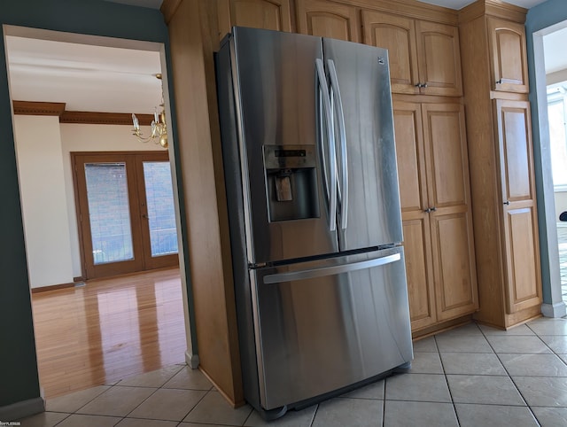 kitchen featuring a notable chandelier, stainless steel fridge, light tile patterned floors, and french doors