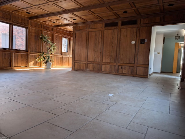 unfurnished room with a healthy amount of sunlight, wooden ceiling, wooden walls, and coffered ceiling