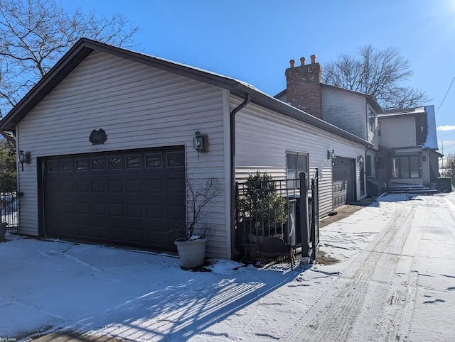 view of snow covered exterior featuring a garage