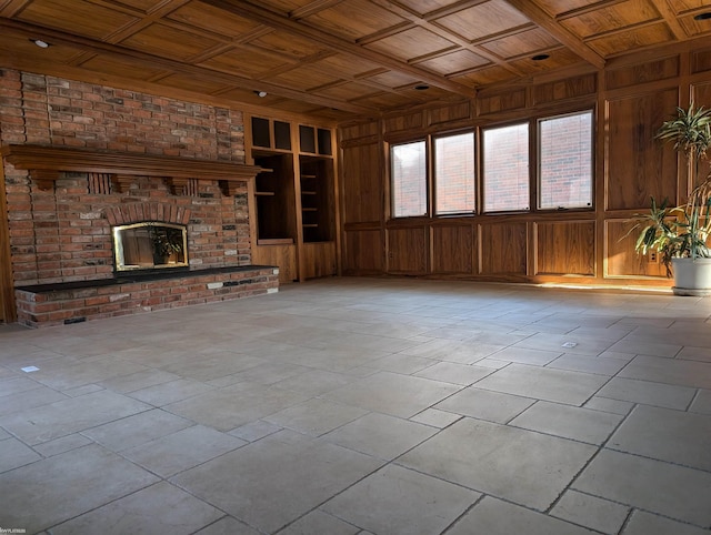 unfurnished living room with a brick fireplace, built in shelves, wood ceiling, and coffered ceiling