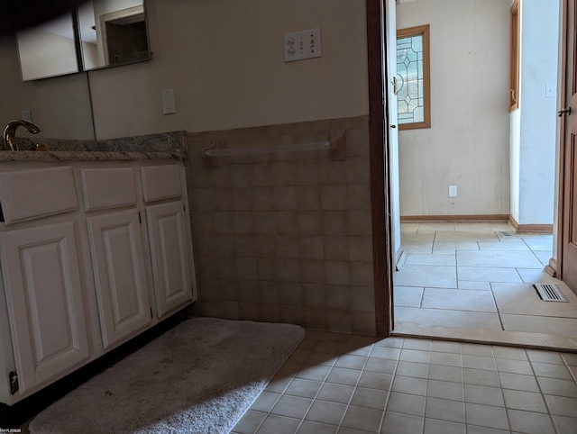 bathroom featuring tile patterned flooring, vanity, and tile walls