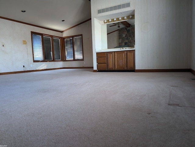 interior space featuring ceiling fan, light colored carpet, lofted ceiling, and ornamental molding