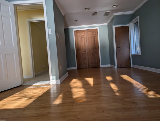 unfurnished bedroom with ornamental molding and dark wood-type flooring