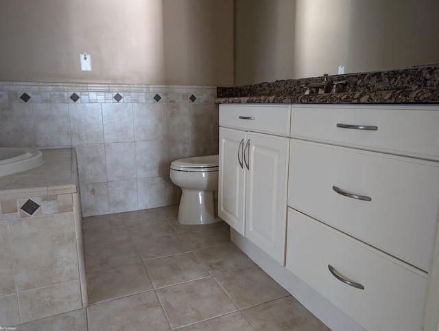 bathroom featuring tile patterned floors, vanity, toilet, and tile walls