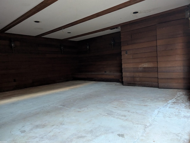 unfurnished room featuring wooden walls