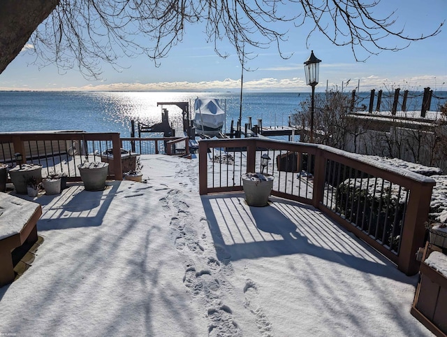 snow covered deck featuring a water view