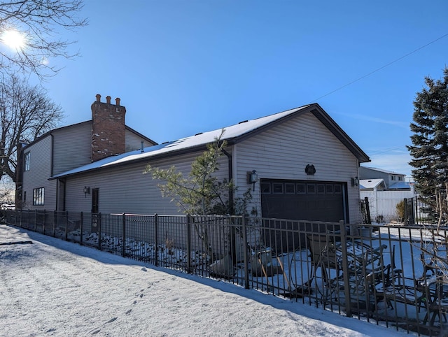 snow covered property featuring a garage