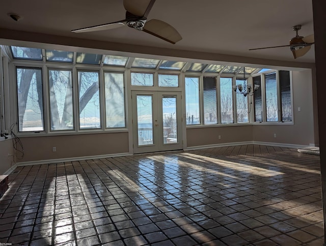 tiled spare room with french doors and ceiling fan with notable chandelier