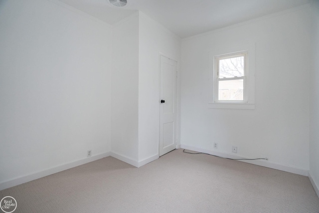 carpeted spare room featuring crown molding