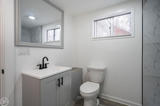 bathroom with hardwood / wood-style flooring, vanity, and toilet