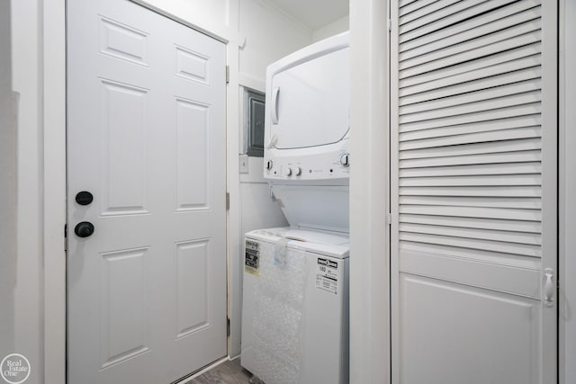 laundry area with hardwood / wood-style floors and stacked washer / drying machine