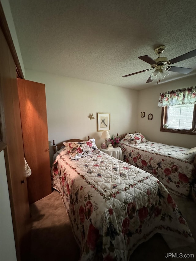 bedroom with ceiling fan and a textured ceiling