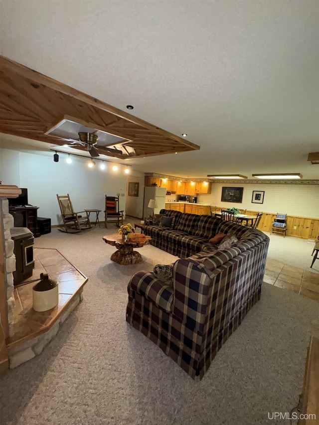 living room featuring a wood stove and ceiling fan