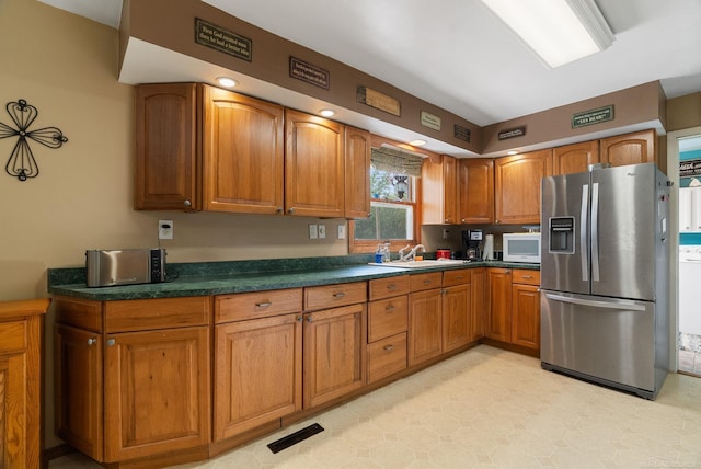 kitchen featuring stainless steel fridge with ice dispenser and sink