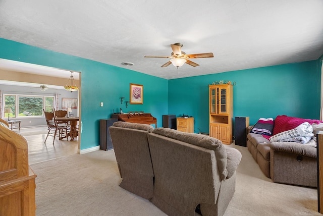 carpeted living room with ceiling fan and a textured ceiling