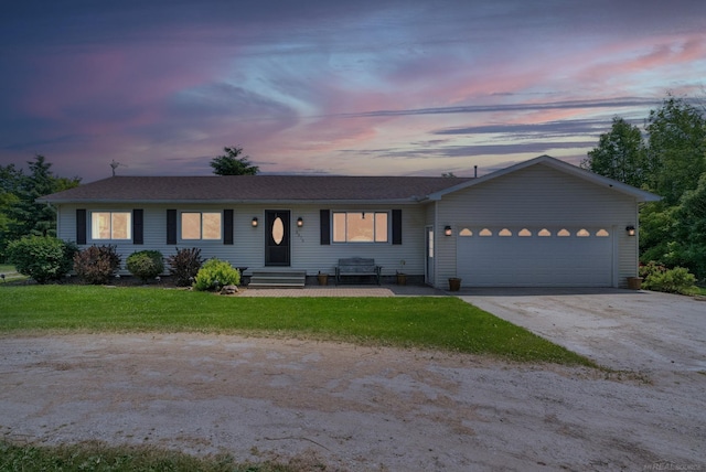 ranch-style home with a yard and a garage