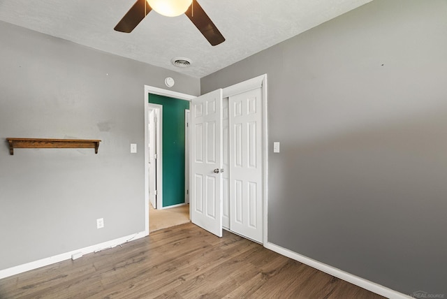 unfurnished bedroom featuring a closet, light hardwood / wood-style flooring, and ceiling fan