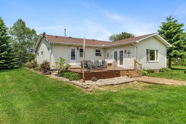 back of property with a yard, a wooden deck, and french doors