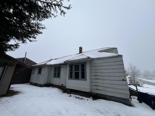 view of snow covered back of property