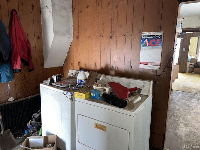 laundry area with washer / dryer, radiator heating unit, and wooden walls