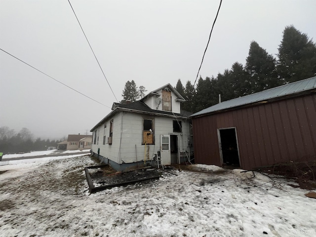 view of snow covered rear of property