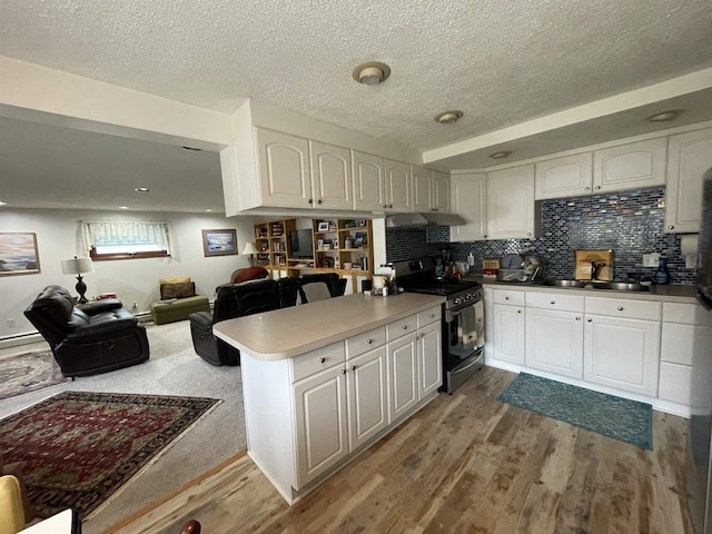 kitchen featuring white cabinetry, sink, kitchen peninsula, black range with gas cooktop, and light wood-type flooring