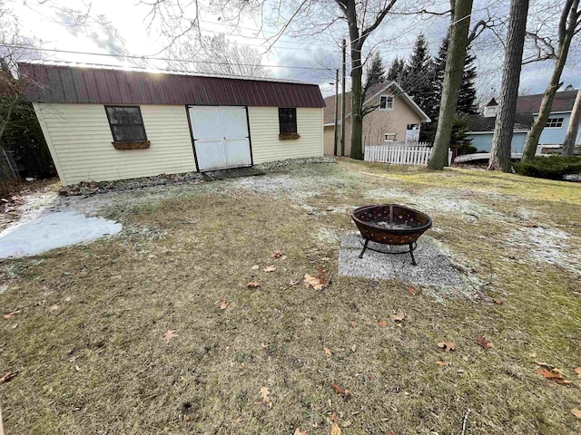 view of yard with an outdoor fire pit and an outdoor structure