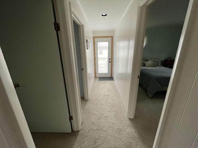 corridor with light colored carpet and ornamental molding