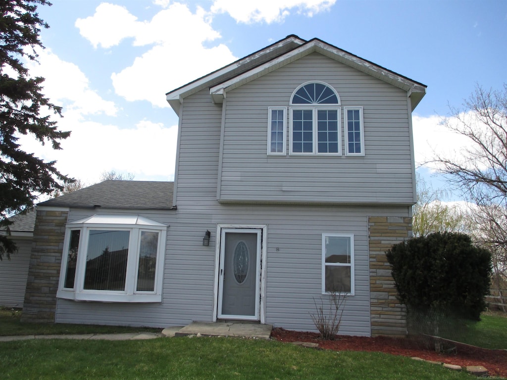 view of property featuring a front lawn