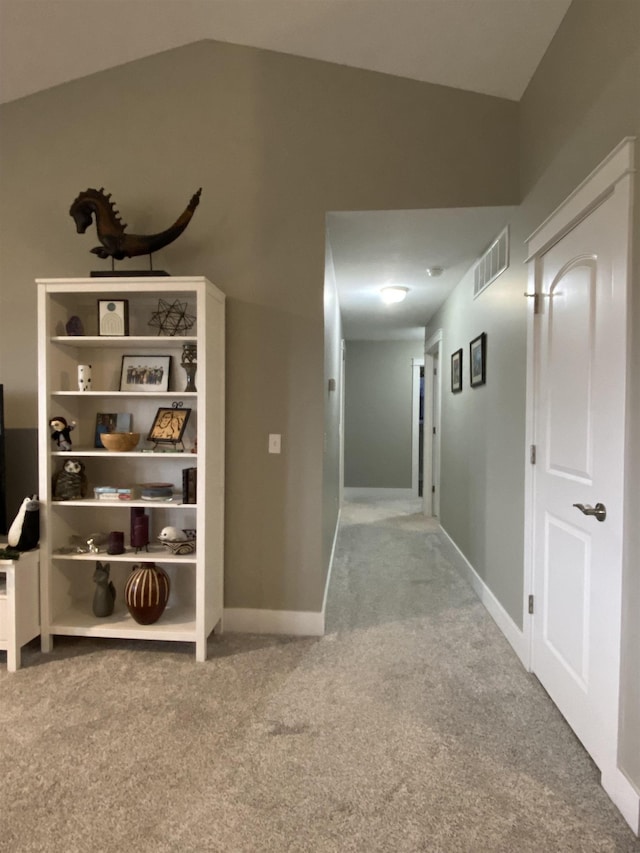 corridor featuring carpet and vaulted ceiling