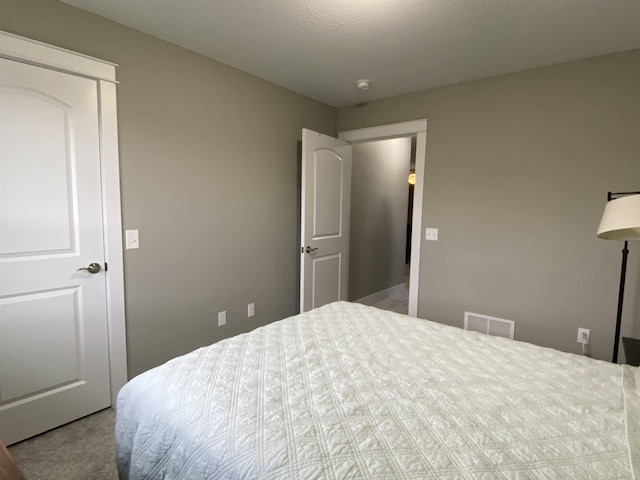 bedroom with a textured ceiling and light carpet