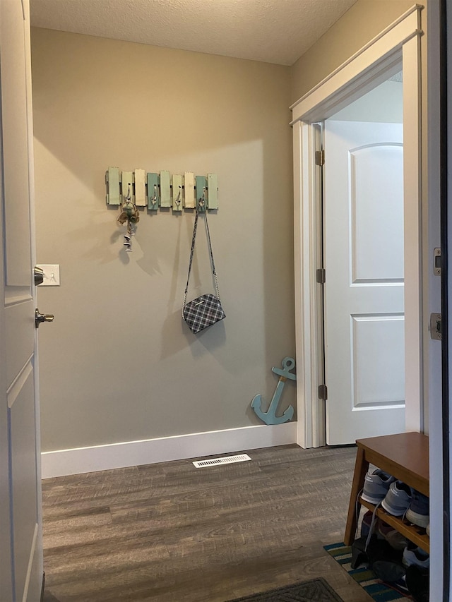 bathroom with wood-type flooring and a textured ceiling