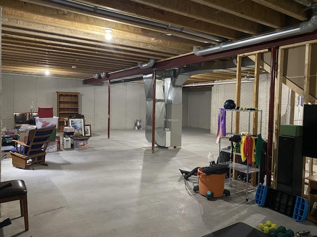 basement with heating unit and brick wall