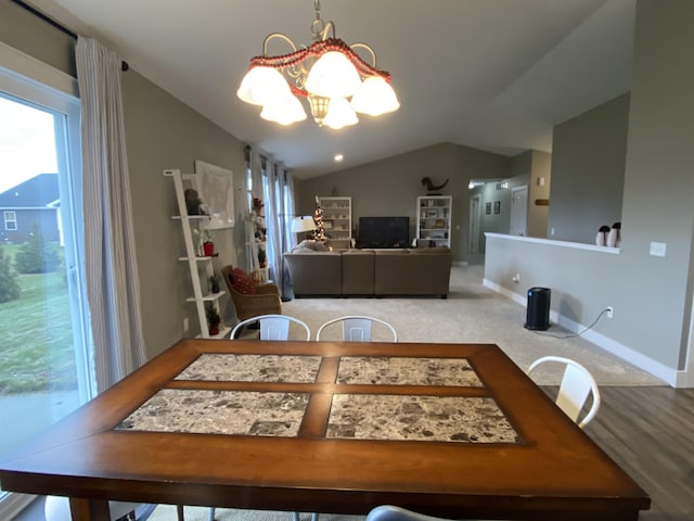 dining space featuring lofted ceiling, carpet floors, and an inviting chandelier