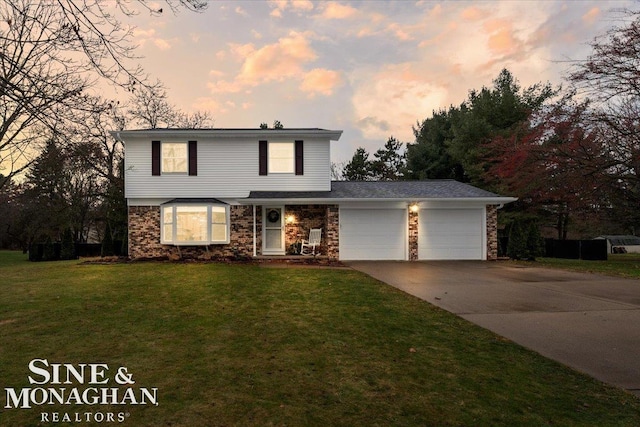 view of property with a garage and a lawn