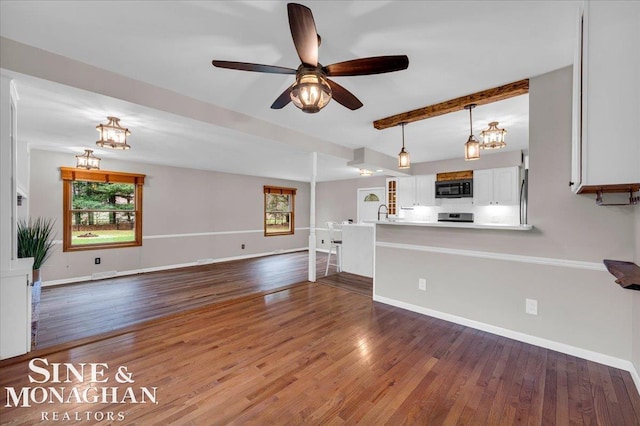 kitchen featuring beam ceiling, white cabinetry, ceiling fan, hanging light fixtures, and hardwood / wood-style flooring