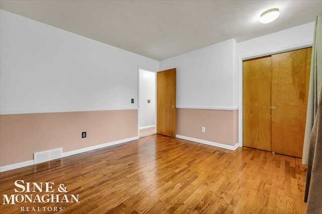 unfurnished bedroom featuring light hardwood / wood-style flooring and a closet