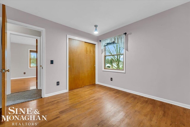 unfurnished bedroom featuring hardwood / wood-style floors and a closet