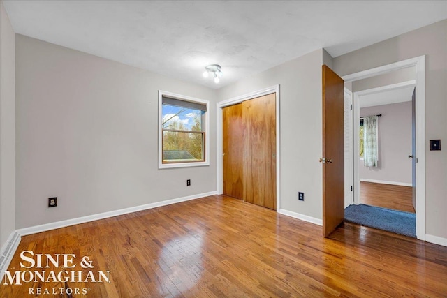 unfurnished bedroom featuring a closet and hardwood / wood-style floors